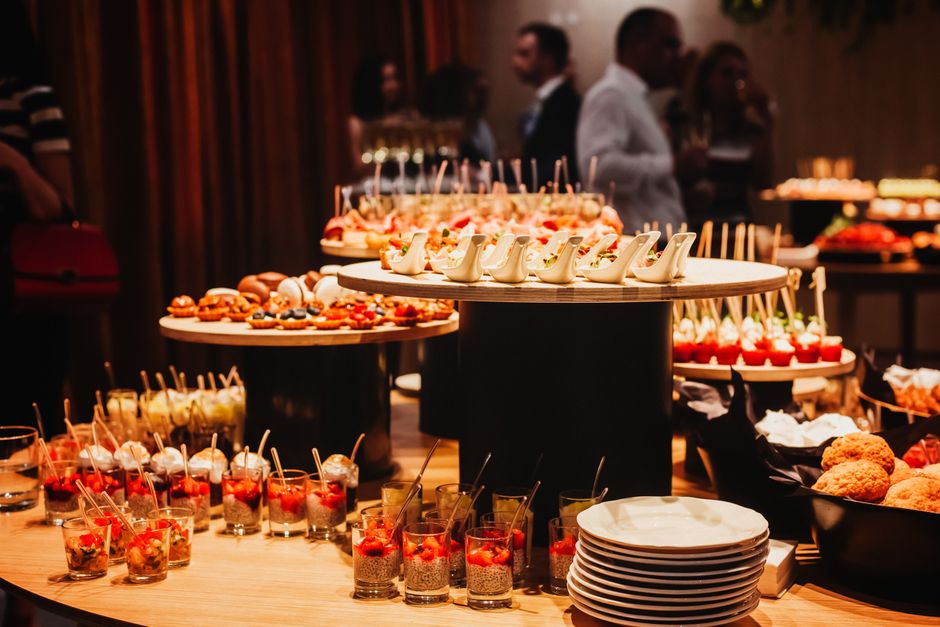 A variety of gourmet appetizers displayed on an elegant buffet table at an indoor event setting.