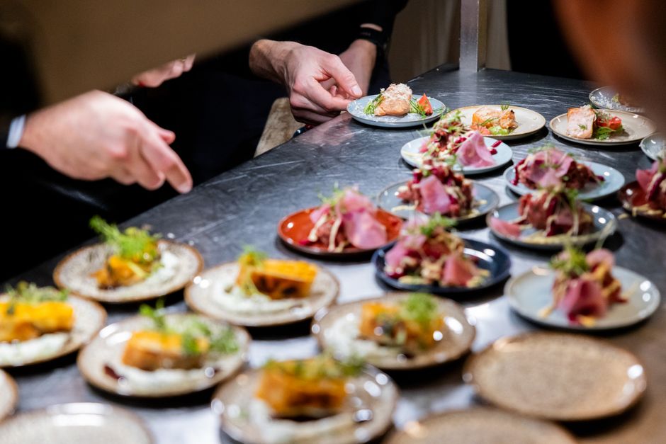 Chefs expertly plate gourmet dishes at a culinary event in Hamburg, showcasing vibrant colors and textures.
